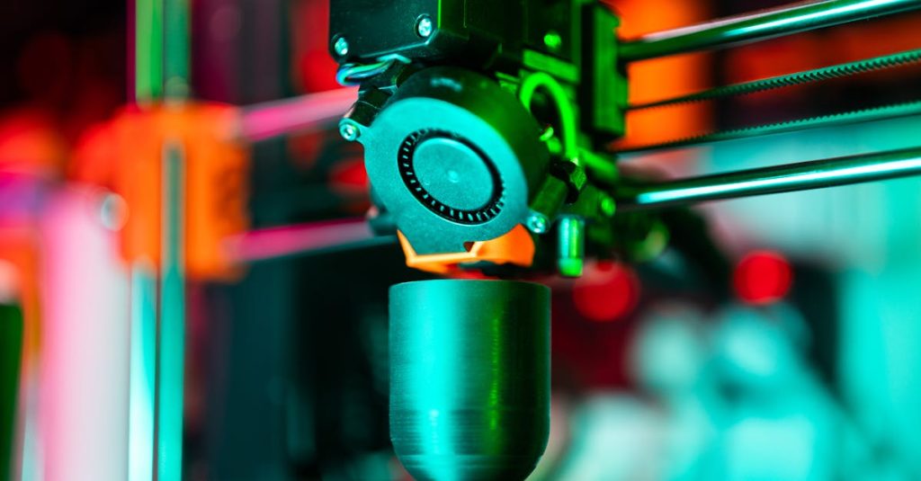 Close-up of a 3D printer creating a product in neon lighting.