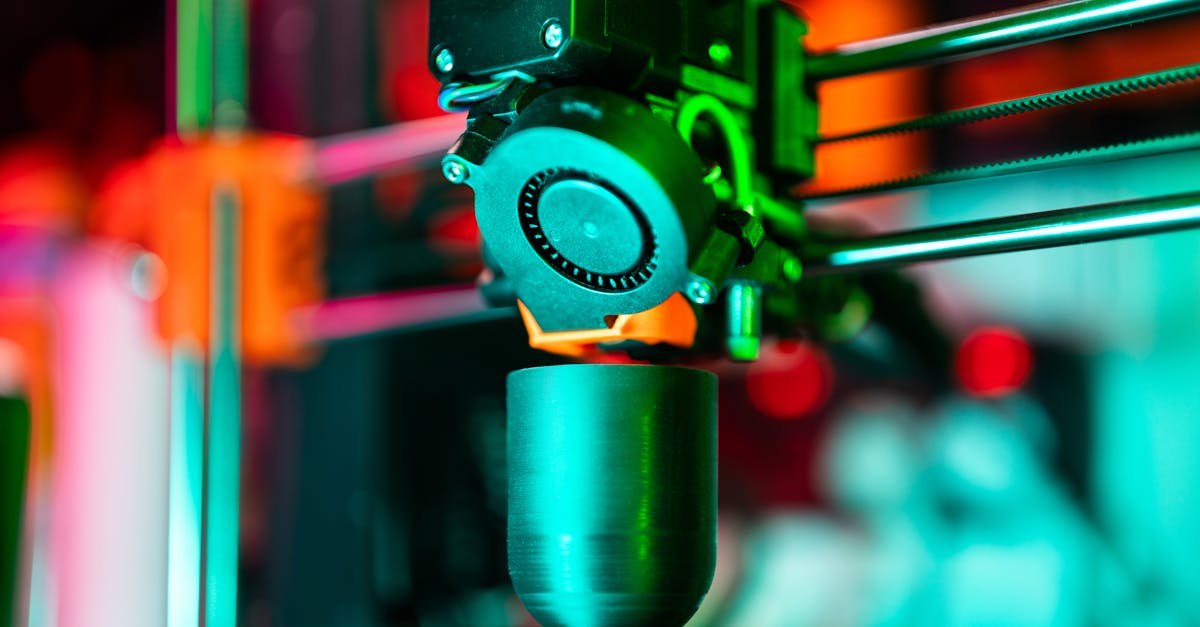 Close-up of a 3D printer creating a product in neon lighting.